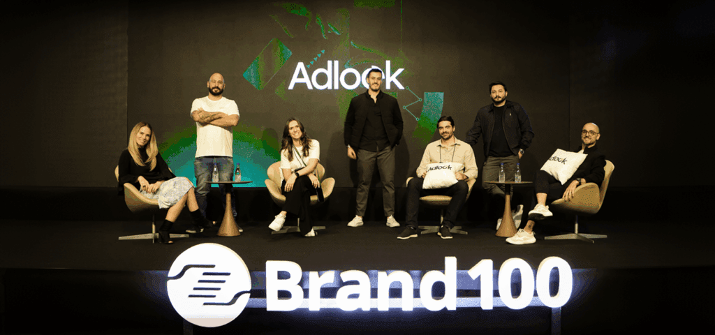 Adlook team on stage at Brand100 event in Brazil, featuring João Sarmento (Sales Director, Team Lead), Rodrigo Lobato (VP of Sales Brazil), Carolyn Max (Marketing & PR Coordinator), and Andre Coiro (VP Client Development LATAM) under Adlook branding.
